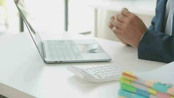 Close up Business woman using calculator and laptop for do math finance on wooden desk, tax, accounting, statistics and analytical research concept video