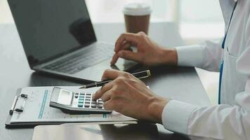 cierre a una mujer de negocios usando una calculadora y una computadora portátil para hacer finanzas matemáticas en un escritorio de madera, impuestos, contabilidad, estadísticas y concepto de investigación analítica video