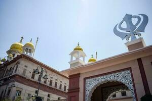 Khanda sij santo religioso símbolo a gurudwara Entrada con brillante azul cielo imagen es tomado a hermana marihuana sahib gurudwara en Chandi choc, opuesto rojo fuerte en antiguo Delhi India foto