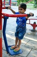 asiático chico haciendo rutina ejercicio en sociedad parque durante el Mañana tiempo. linda pequeño niño ejercicio y gimnasio a mantener él mismo ajuste para vida. niño ejercicio al aire libre disparar foto