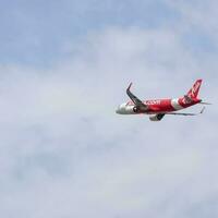 New Delhi, India, April 16 2023 - Air Asia Airbus A320 take off from Indra Gandhi International Airport Delhi, Air Asia domestic aeroplane flying in the blue sky during day time photo