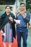 New Delhi, India - December 04 2022 - Unidentified people showing their ink-marked fingers after casting votes in front of polling booth of east Delhi area for MCD local body Elections 2022 photo
