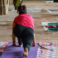 inspirado indio joven mujer haciendo yoga asanas en lodhi jardín parque, nuevo Delhi, India. joven ciudadano hacer ejercicio fuera de y en pie en yoga lado ángulo pose. aptitud al aire libre y vida equilibrar concepto foto