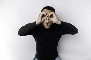 Funny obvious peeking Asian man in black shirt isolated on white background. photo