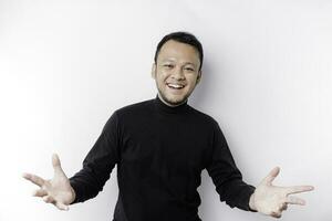 Young Asian man wearing black t-shirt presenting an idea while looking smiling on isolated white background photo