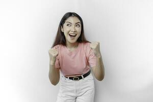 un joven asiático mujer con un contento exitoso expresión vistiendo rosado camiseta aislado por blanco antecedentes foto