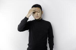 A portrait of an Asian man wearing a black shirt isolated by white background looks depressed photo