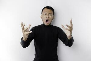 The angry and mad face of Asian man in black shirt isolated white background. photo