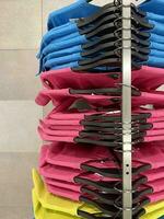 Clothes hang on a hanger in the store. Style and wardrobe. Bright clothes photo