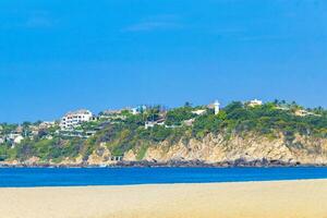 Sun beach sand people surfer waves palms Puerto Escondido Mexico. photo