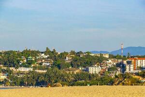 Sun beach sand people surfer waves palms Puerto Escondido Mexico. photo