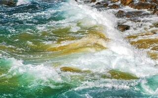 Surfer waves turquoise blue water rocks cliffs boulders Puerto Escondido. photo