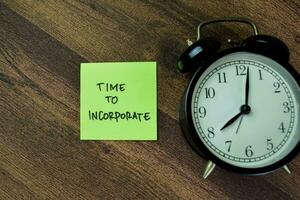 Concept of Time to Incorporate write on sticky notes isolated on Wooden Table. photo