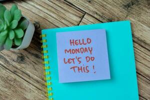 Concept of Hello Monday Let's Do This write on sticky notes isolated on Wooden Table. photo