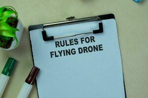 Concept of Rules For Flying Drone write on paperwork isolated on Wooden Table. photo