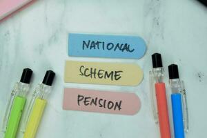 Concept of National Scheme Pension write on sticky notes isolated on Wooden Table. photo