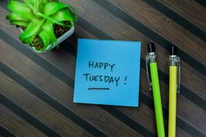 Concept of Happy Tuesday write on sticky notes isolated on Wooden Table. photo