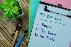 Concept of To Do List write on paperwork, Supported by an additional services isolated on Wooden Table. photo