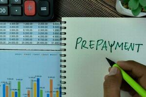 Concept of Prepayment write on a book isolated on Wooden Table. photo