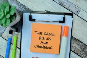 Concept of The Game Rules Are Changing write on sticky notes isolated on Wooden Table. photo