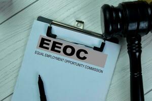 Concept of EEOC - Equal Empoyment Opportunity Commission write on paperwork isolated on Wooden Table. photo