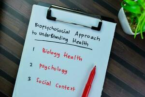 Concept of Biopsychosocial Approach to Understanding Health write on paperwork isolated on Wooden Table. photo