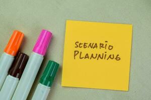 Concept of Scenario Planning write on sticky notes isolated on Wooden Table. photo