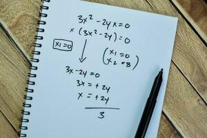 Concept of math formulas write on book isolated on Wooden Table. photo