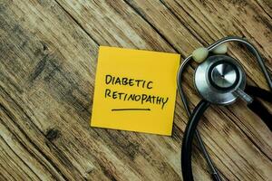 Concept of Diabetic Retinopathy write on sticky notes with stethoscope isolated on Wooden Table. photo