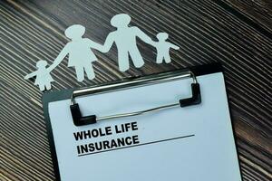 Concept of Whole Life Insurance write on paperwork isolated on Wooden Table. photo