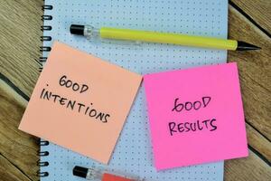 Concept of Good Intentions and Good Results write on sticky notes isolated on Wooden Table. photo