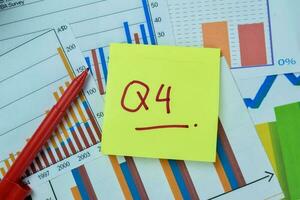 Concept of Q4 - 4th Quarter Period write on sticky notes isolated on Wooden Table. photo