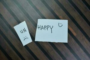 Concept of Happy write on sticky notes isolated on Wooden Table. photo