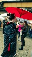 Kyoto, Japan in April 2019. A geisha wearing a kimono walking in the Gion district. photo