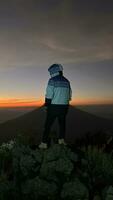 The Man greets the sunrise in the mountains. A man greet the dawn. West Java, Indonesia, March 16, 2023 photo