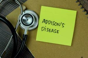 Concept of Addison's Disease write on sticky notes with stethoscope isolated on Wooden Table. photo