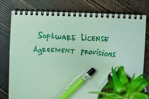 Concept of Software License Agreement Provisions write on a book isolated on Wooden Table. photo