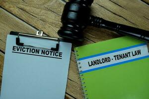 Concept of Eviction Notice write on paperwork and Landlord - Tenant Law on a book isolated on Wooden Table. photo