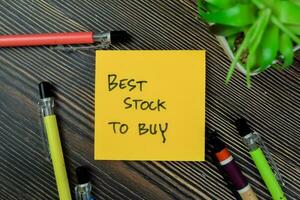 Concept of Best Stock To Buy write on sticky notes isolated on Wooden Table. photo