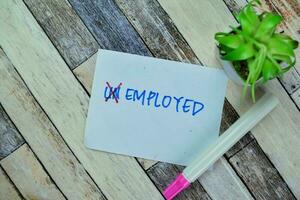 Concept of Unemployed to be Employed write on sticky notes isolated on Wooden Table. photo