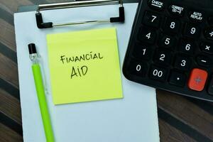 Concept of Financial Aid write on book isolated on Wooden Table. photo