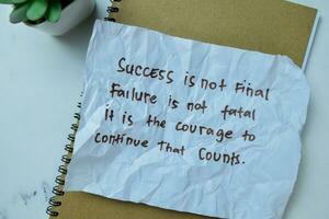 Concept of Success Is Not Final Failure Is Not Fatal It is The Courage to Continue That Counts write on sticky notes isolated on Wooden Table. photo