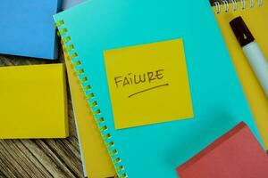 Concept of Failure write on sticky notes isolated on Wooden Table. photo