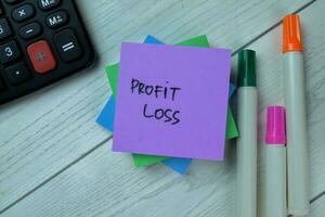 Concept of Profit Loss write on sticky notes isolated on Wooden Table. photo