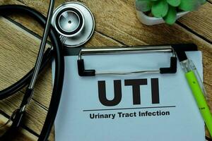 Concept of UTI - Urinary Tract Infection write on paperwork isolated on Wooden Table. photo