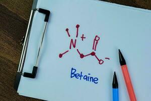 Concept of Betaine Molecule write on paperwork, structural chemical formula isolated on Wooden Table. photo