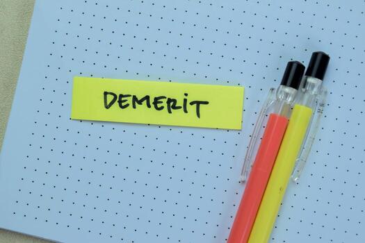 Concept of Demerit write on sticky notes isolated on Wooden Table. photo