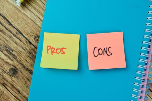 Concept of Pros or Cons write on sticky notes isolated on Wooden Table. photo