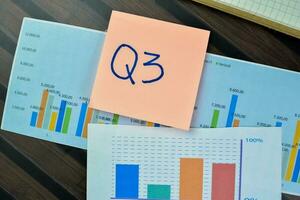 Concept of Q3 - 3rd Quarter Period write on sticky notes isolated on Wooden Table. photo