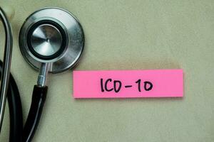 Concept of ICD-10 write on sticky notes with stethoscope isolated on Wooden Table. photo